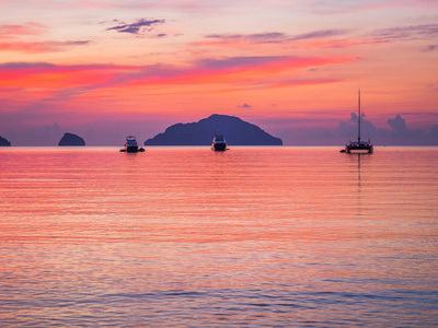 日落时分，三艘船停泊在安静的海湾里，红天平静的景象，完美的背景