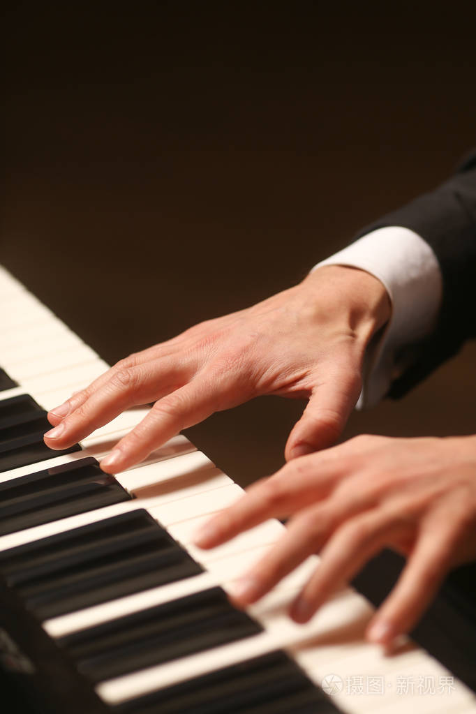 手拿钢琴. 钢琴家弹钢琴. 黑色背景钢琴键