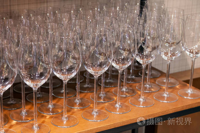 许多透明的水晶酒杯排在架子的棕色木架上。 侧视。 在苏格兰或爱尔兰的生产中品尝威士忌白兰地港口的概念