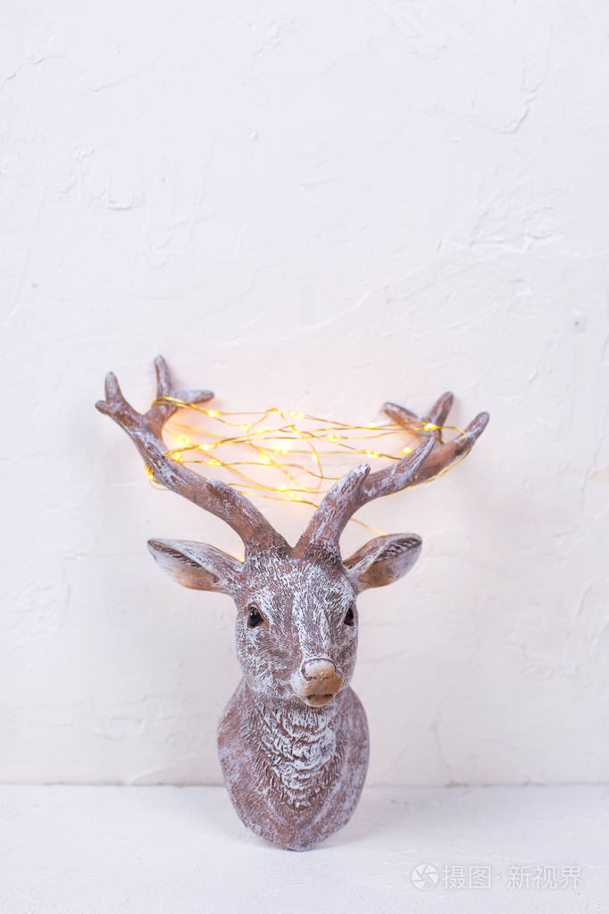 白色背景鹿角上有仙女灯的新年驯鹿装饰头