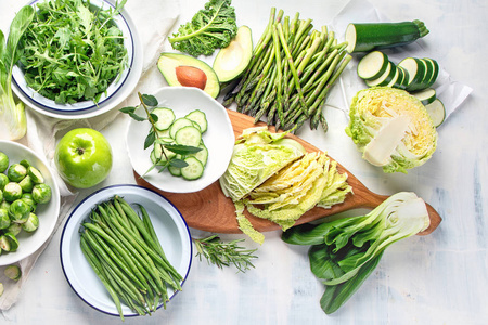 绿色美味蔬菜的顶部景观，健康烹饪，素食和纯素食物在桌面上。
