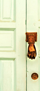 门上有黄铜门响器，手的形状，漂亮的入口，房子的老式装饰。