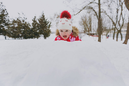 性格开朗的小女孩在冬天穿暖和的衣服和帽子，在雪地公园或户外森林里打雪球。 假日的冬季乐趣休闲。 恋爱关系家庭童年生活方式