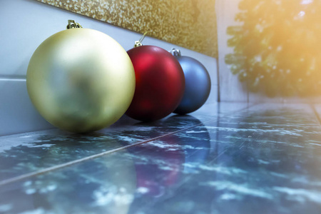 三个不同颜色的圣诞球排成一排，有反光和文字空间