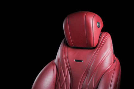红色皮革内饰的豪华现代汽车。 穿孔红色皮革舒适座椅与缝纫隔离在黑色背景。 现代汽车内饰细节。 汽车细节。 汽车里面