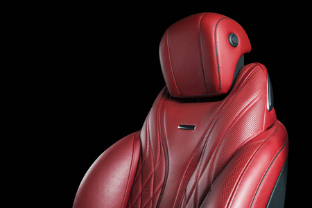 红色皮革内饰的豪华现代汽车。 穿孔红色皮革舒适座椅与缝纫隔离在黑色背景。 现代汽车内饰细节。 汽车细节。 汽车里面