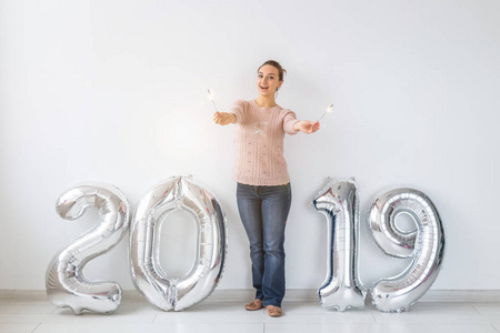 党节日和人概念愉快的年轻妇女庆祝新年与伟大的2019年标志和火花