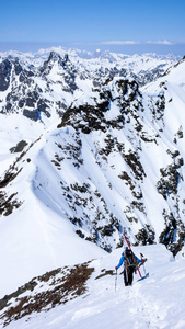 在瑞士阿尔卑斯山, 乡村滑雪者沿着狭窄的山脊徒步旅行