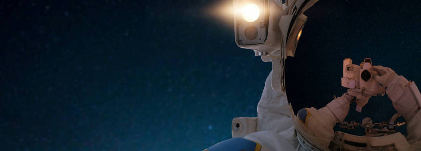 外层空间的宇航员在相机上自拍。 太空人在太空中以恒星为背景旅行。 快关门。