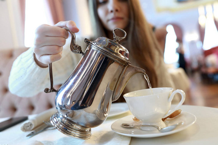 年轻女子在餐馆里倒茶