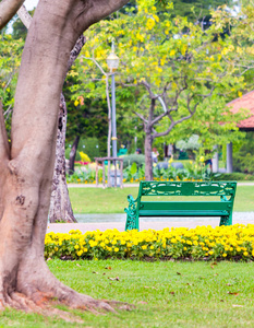 绿色椅子在舒适的家庭花园和花盆装饰夏季。