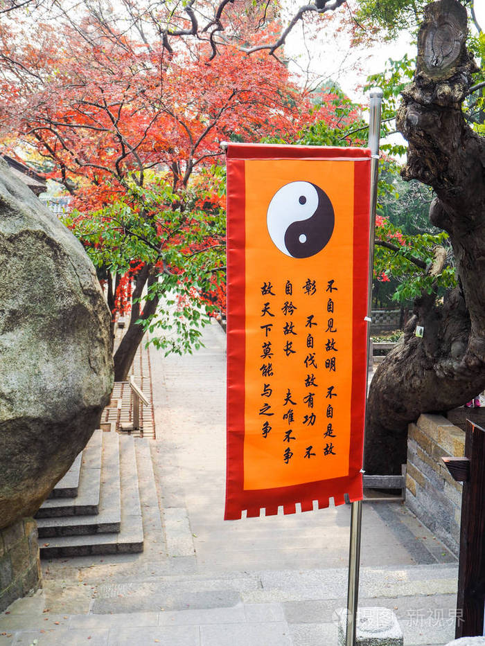 青岛中国2017年12月:在崂山太清寺主院悬挂着阴阳符号的橙色道教旗帜