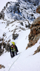 登山女登山者在一条陡峭的路线上到达瑞士阿尔卑斯山上的一座高山峰