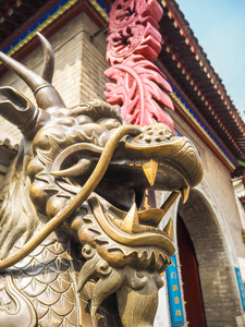 皇庙天津天皇庙入口处一座长有鹿角和胡须的中国传奇龙铜像照片