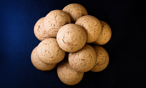 新鲜的棕色饼干在黑暗的背景上. 健康的食物和饮食.照片