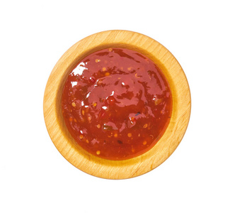 红色辣椒酱在木制碗中分离在白色背景上。
