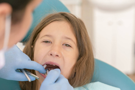 s . little girl sitting in a chair near a dentist after de