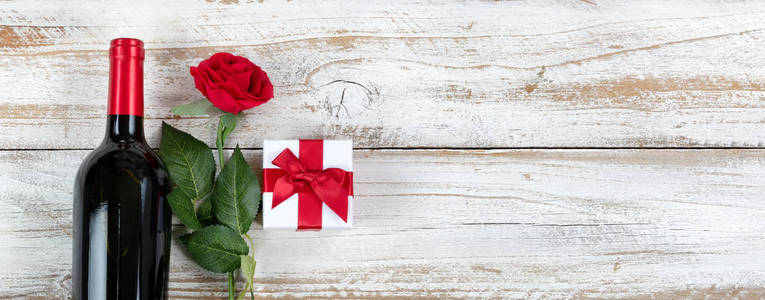 浪漫的情人节庆祝活动，红酒和白色乡村木材上的礼物