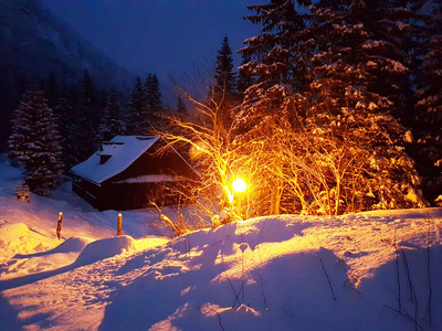 冬季傍晚的风景。 覆盖着雪澄清的街道电灯的木屋。 在山上和森林里过冬。 浪漫的心情和美丽的自然。