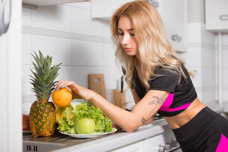 运动妇女拿着橙色水果厨房健康饮食观念