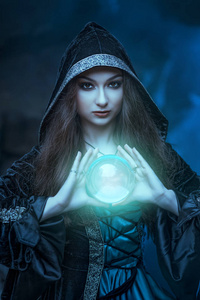 女巫与魔球在她的手中引起精神照片