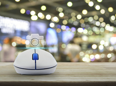 相机平面图标与无线电脑鼠标在木桌上模糊光影商场商业摄像店网上概念