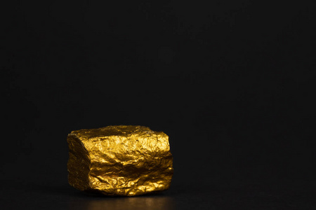 在黑色背景宝石或金石上特写金块或金矿石的财务和商业理念.照片
