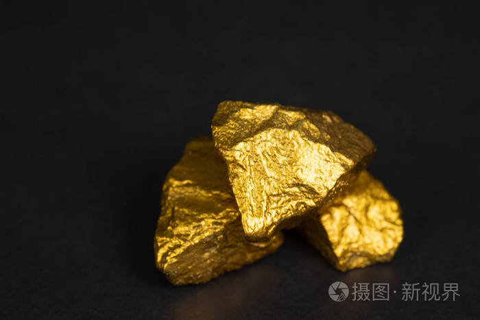 一堆金块或金矿石上的黑色背景宝石或一块金石金融和商业概念