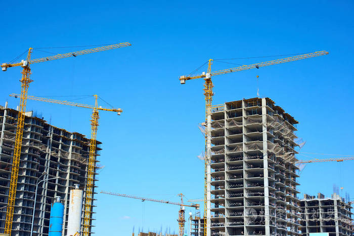 正在施工的建筑物和起重机.在建高层建筑.公寓楼在建,吊车顶着蓝天.