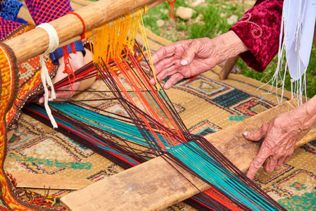 地毯编织。女人手在织布机上织地毯。