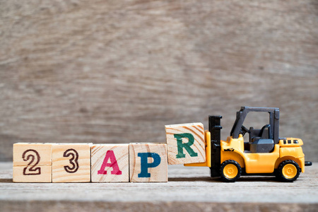 玩具叉车保持块r完成字23apr在木材背景概念日历日期23在4月