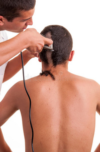 理发师用剪刀给一个年轻人理发图片