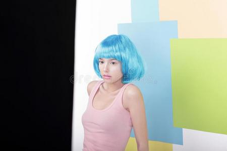 有趣的女孩戴着漂亮的蓝色假发和粉红色的背心