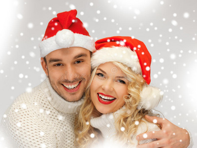 一对夫妇穿着毛衣戴着圣诞老人的帽子