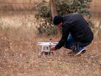 一名无人机飞行员在飞行前在森林中配置他的无人机