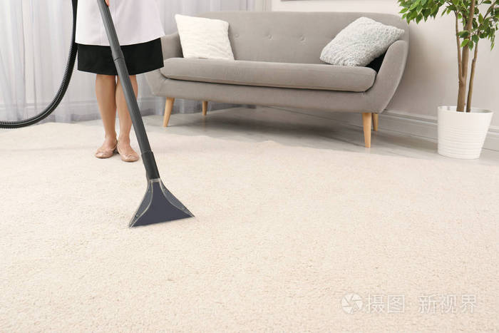 室内女佣用吸尘器清除地毯上的污垢室内特写文本空间