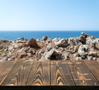 在美丽的夏日，外面有海景的木桌。 乡村木制书桌户外海景背景。 模板模拟与台面产品广告
