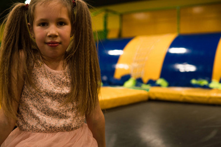 孩子们在游戏室的蹦床操场上的一个小女孩的肖像