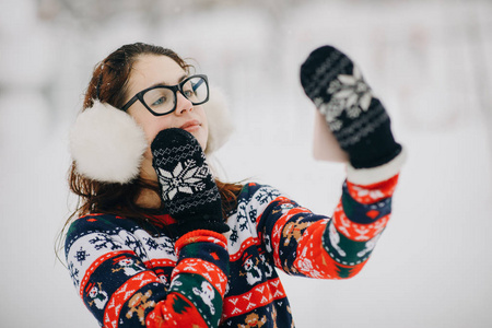 女人在冬季公园里自拍自拍。在冬季公园里, 微笑的女孩在雪树的背景下自拍自拍