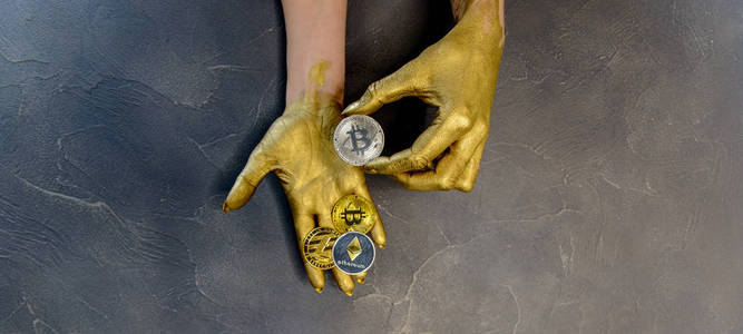 s hands painted with gold paint hold crypto currency