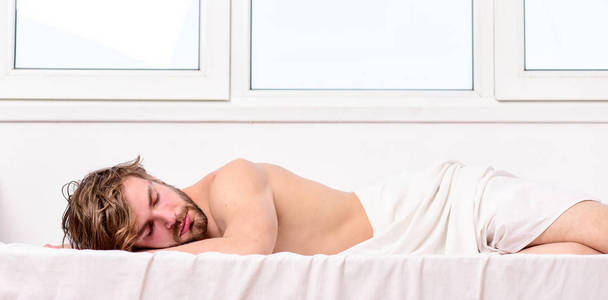 男人帅哥睡觉。睡眠对你的身心健康至关重要。健康的睡眠习惯。男人没有刮胡子的脸睡床。午睡时间到了睡眠和放松的概念。感觉舒适和放松