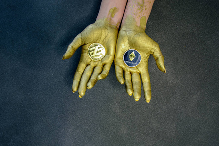 s hands painted with gold paint hold crypto currency