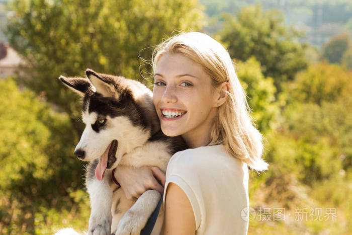 犬的同伴.快乐的狗主人玩与家庭宠物户外.性感的女人与狗宠物在夏天的