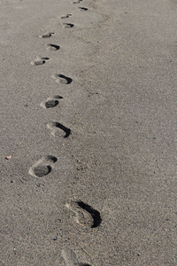 沙子纹理上的脚印。 夏季海滩背景。