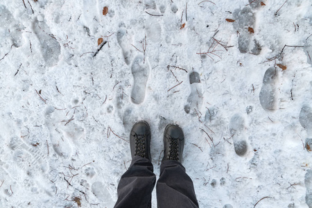 男性脚在靴子站立在雪, 顶视图