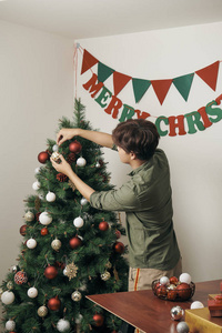 快乐男人在家装饰圣诞树