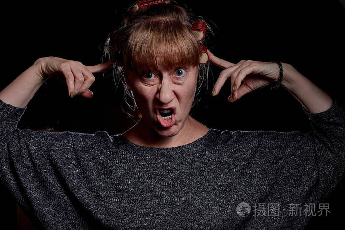 女人有卷发脸上有有趣的情绪愤怒怨恨痛苦暗键摄影