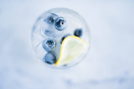 喝鸡尾酒和庆祝风格的概念鸡尾酒与蓝莓冰和柠檬优雅的视觉。