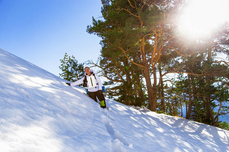 在阳光明媚的日子里，带着装备的年轻女孩山区游客在冬天穿过卡拉恰伊谢尔凯西亚山脉的大雪。