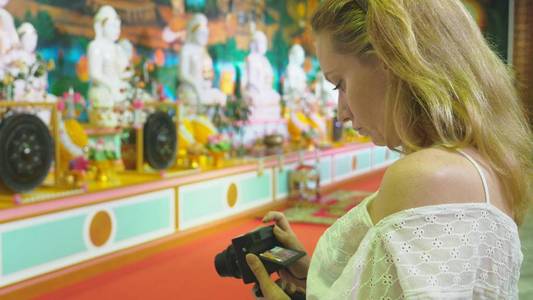 亚洲旅游业的概念。欧洲妇女白色头发和蓝色眼睛的游客在佛教寺庙看见风景